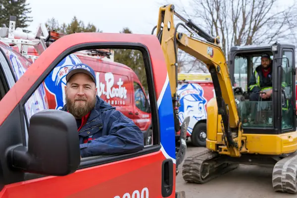 Mr. Rooter professional standing outside of a branded truck.