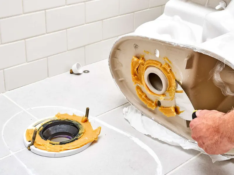 Image of lifting and resetting a toilet.