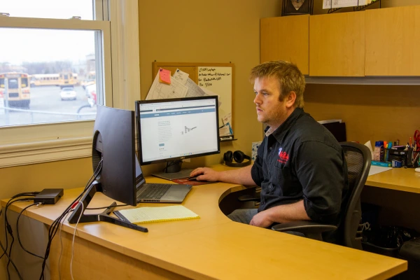Mr. Rooter employee sitting at a desk.