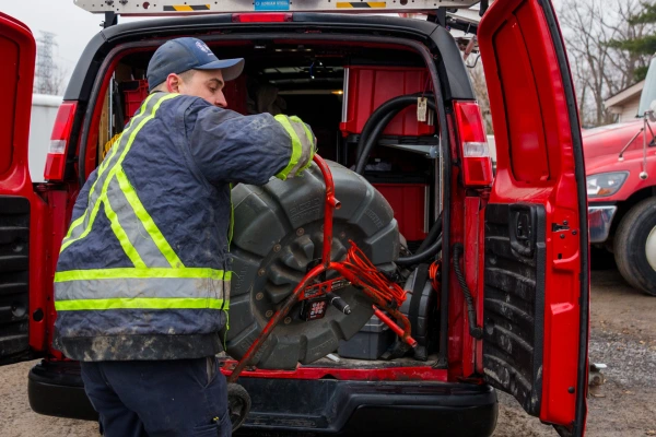 Mr. Rooter technician removing equipment from a van.