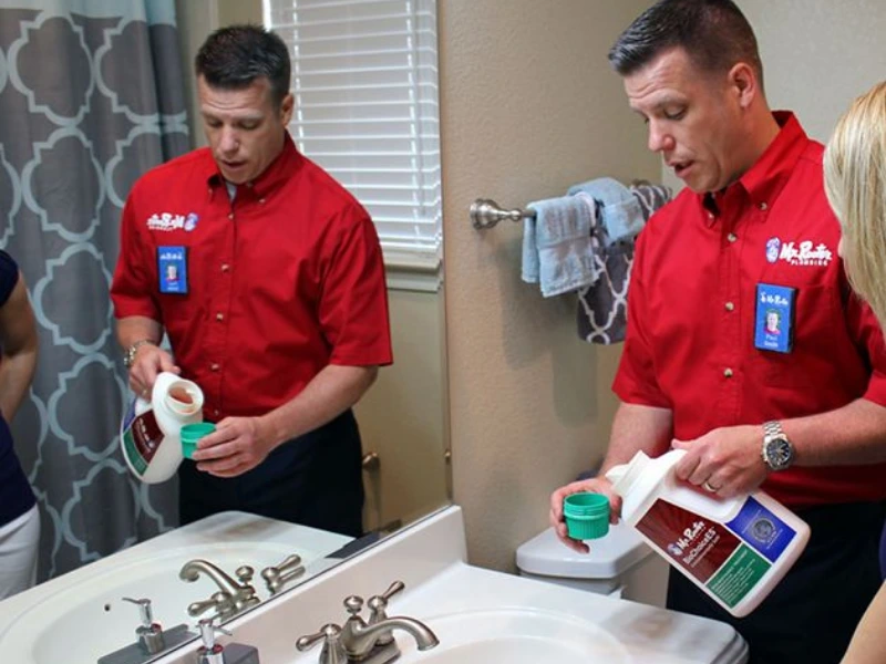 Mr. Rooter professional unclogging a drain.