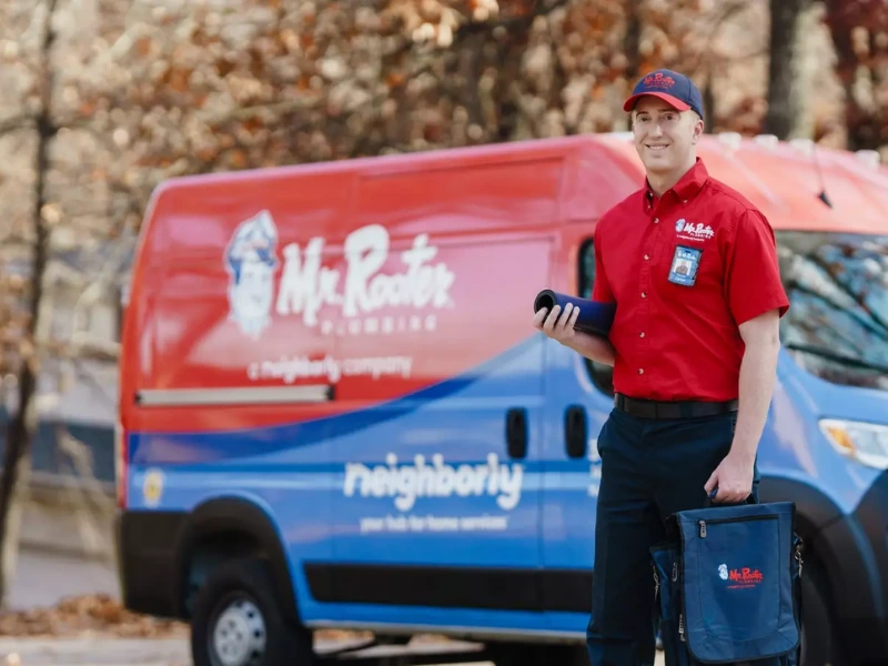 Mr. Rooter professional standing by branded van.