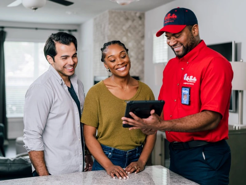 Mr. Rooter employee working with two customers.