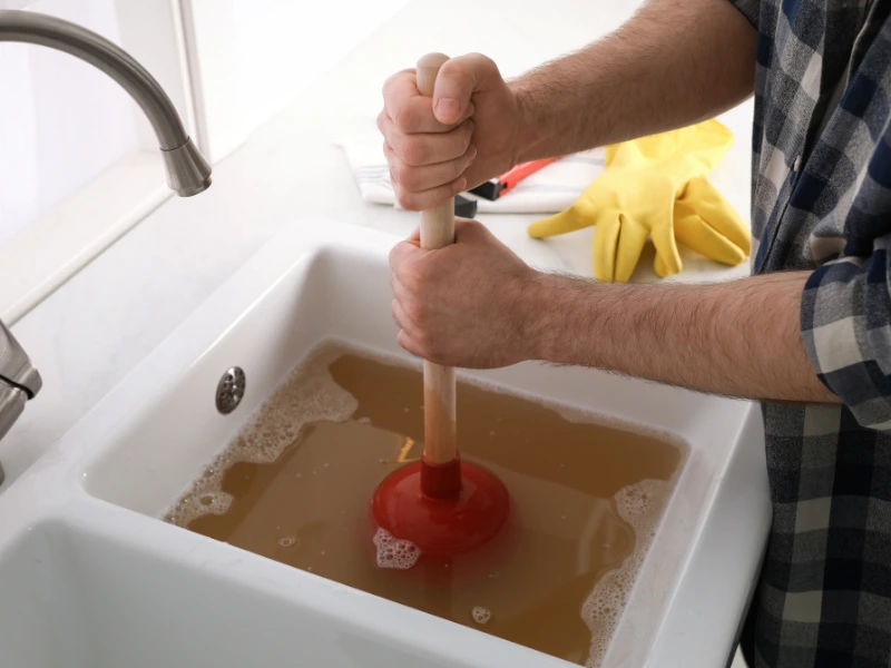 Person plunging a clogged sink.