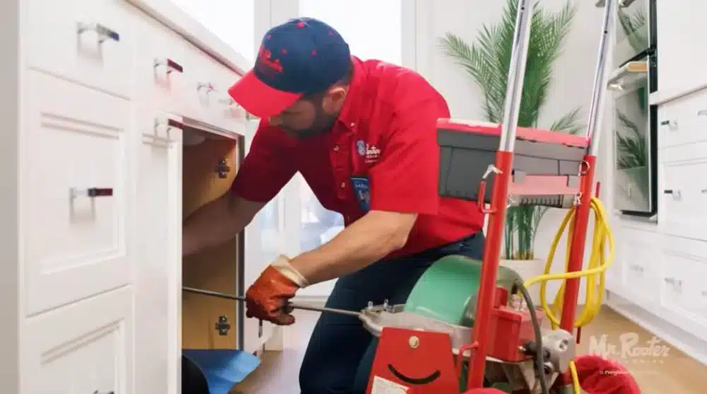 A Mr. Rooter employee fixing a clogged drain